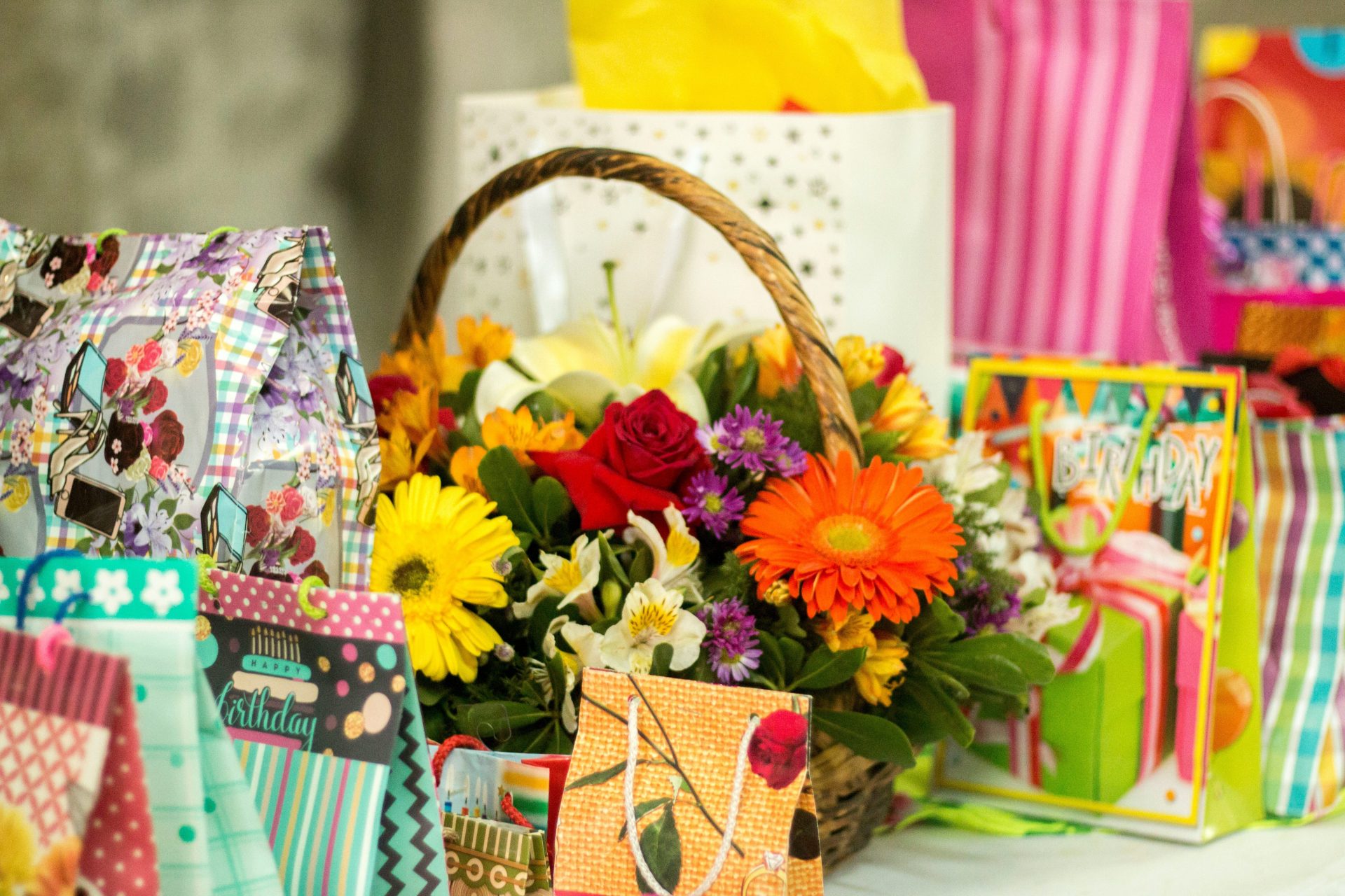 yellow red and white flowers in brown basket